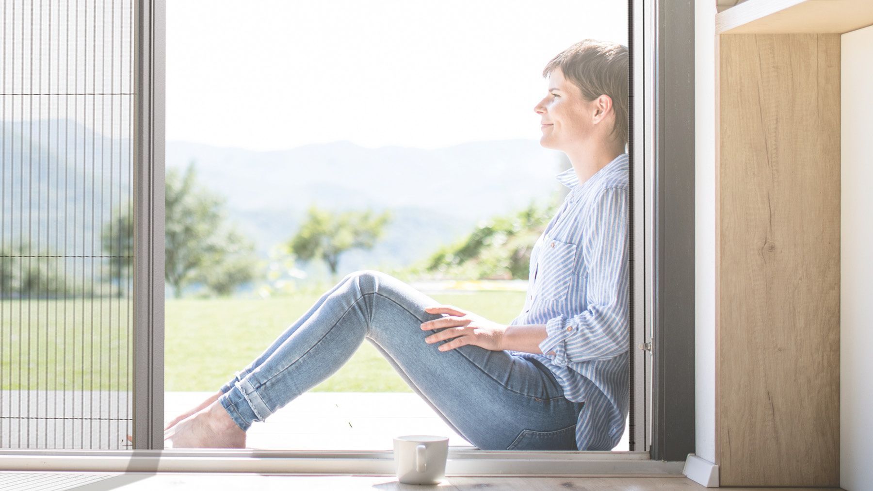 Frau sitzt in Teba Plisseetür für Insektenschutz