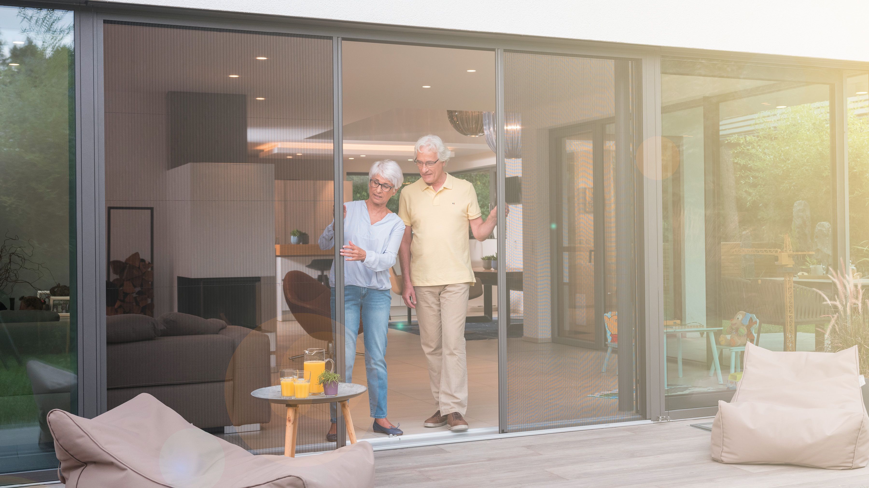 Mann und Frau öffnen Insektenschutz Plisseetüren