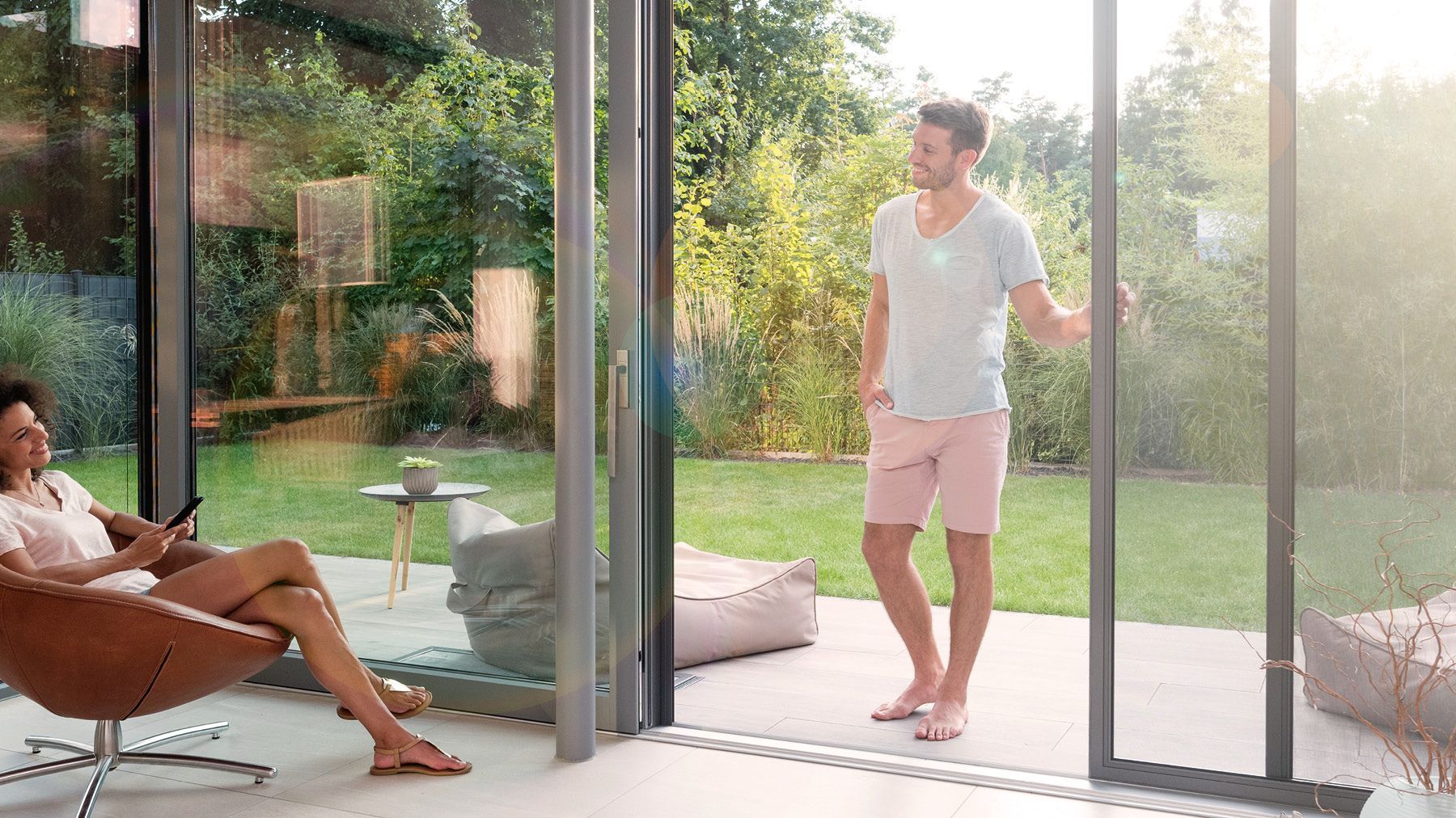 Mann öffnet Teba Insektenschutz Schiebetür