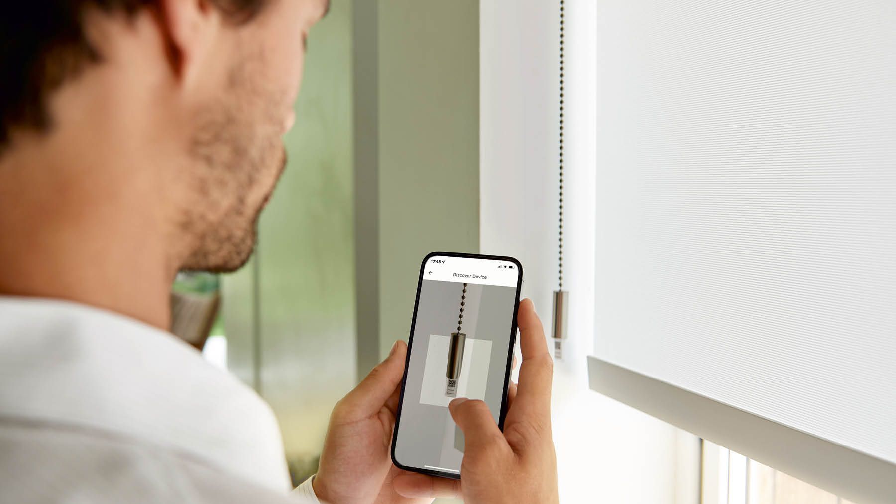 Mann bedient Teba eve MotionsBlinds am IPhone