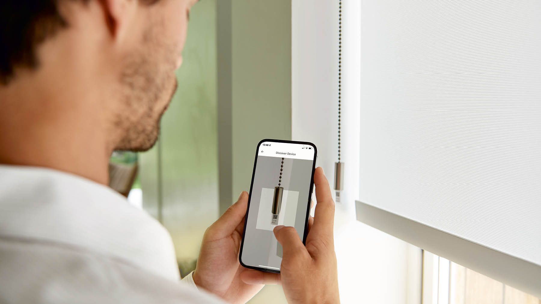 Mann bedient Teba MotionsBlinds am IPhone