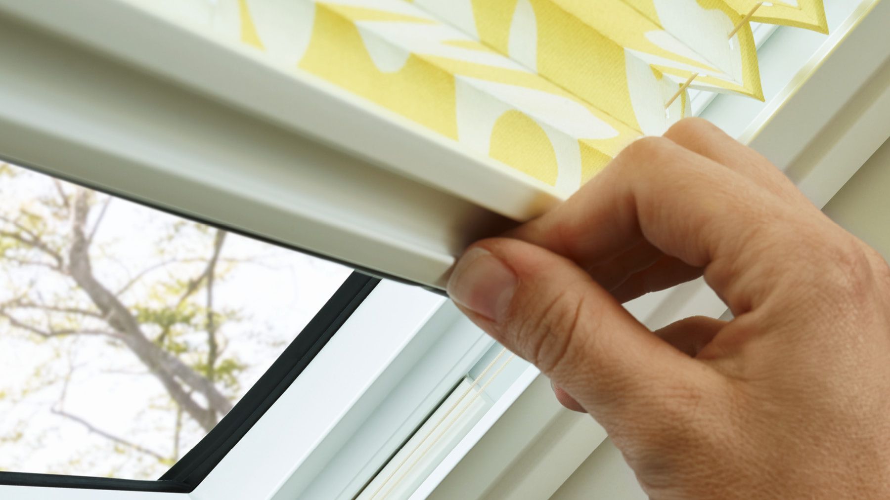 Gelbes Plissee Dachfenster Hand