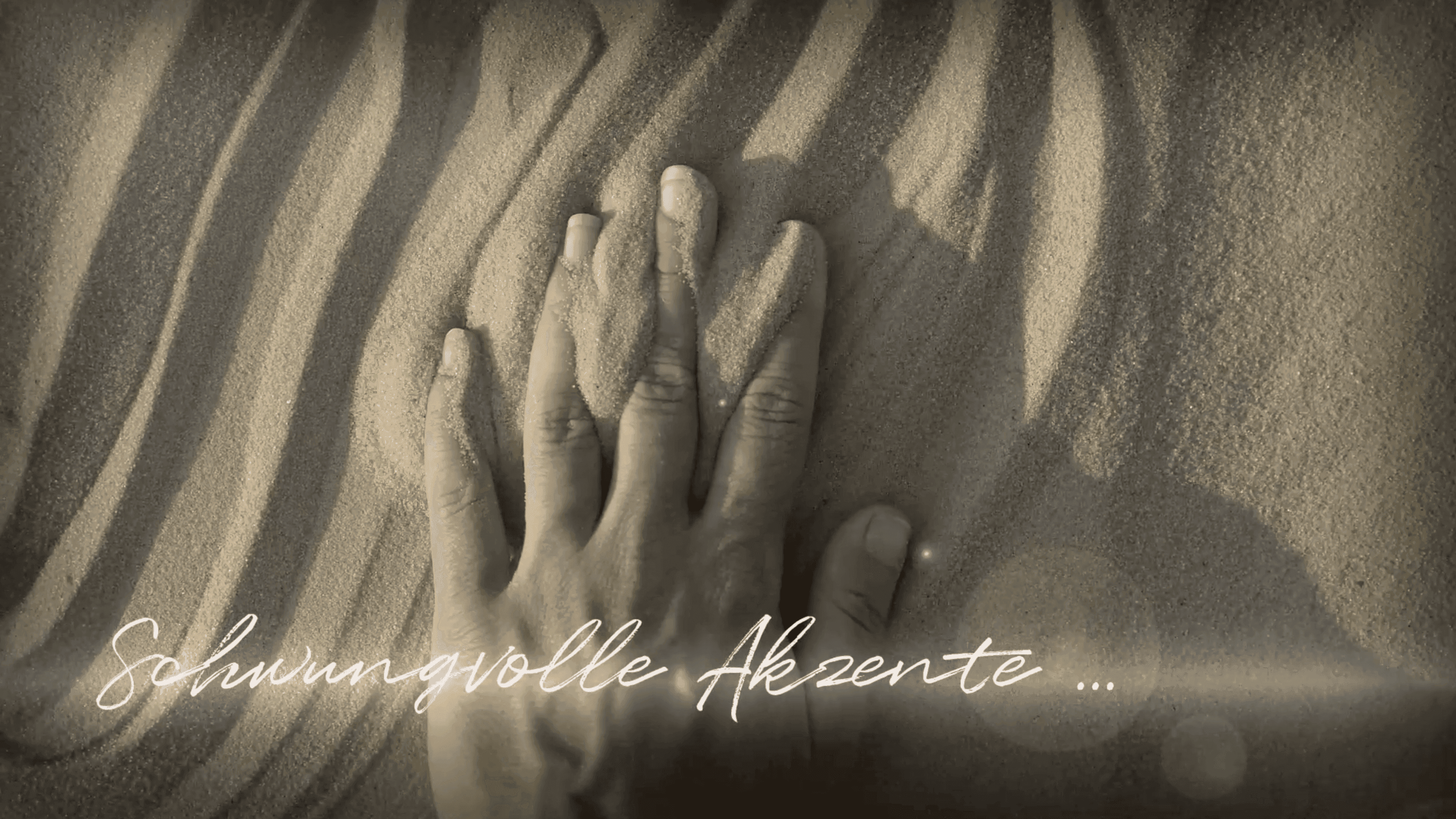 Hand fährt durch Sand