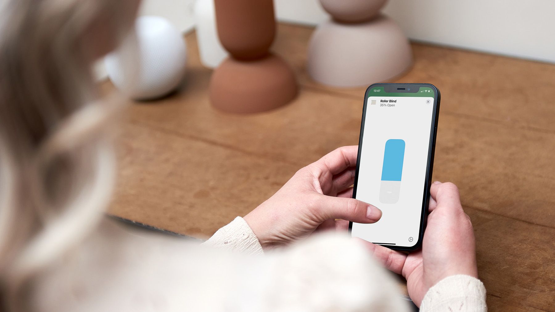 Frau bedient Eve Motionsblinds am Handy