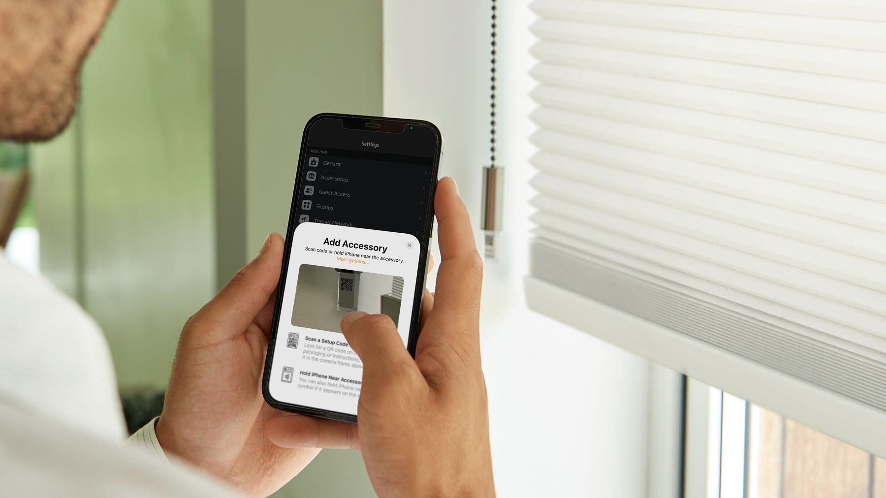 Mann bedient Eve Motionsblinds am Handy